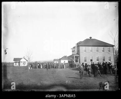 Un gruppo di visitatori è riunito presso la Umatilla Indian School, che mostra un'assemblea diversificata di individui presso l'istituto educativo. Foto Stock