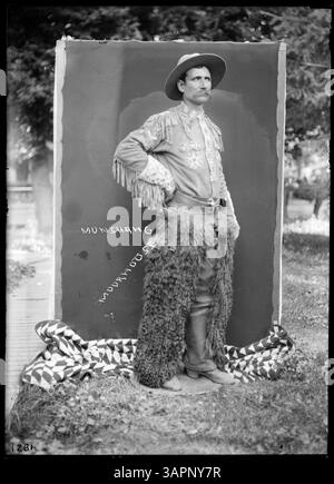 Questa fotografia di Lee Moorhouse raffigura Munshang il cowboy in costume, che tiene in mano un fucile. Il ritratto a figura intera fa parte della collezione di fotografie storiche della University of Oregon Libraries. Foto Stock