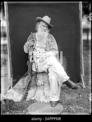 Un'immagine a figura intera di Joaquin Miller in costume di frontiera, con un fucile, catturato da Lee Moorhouse. Foto Stock