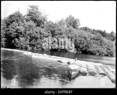 Questa fotografia raffigura una donna in una barca a remi all'interno di un boom di tronchi sul fiume grande Ronde vicino a Hilgard, Oregon, che cattura un momento di vita quotidiana nell'Oregon dei primi anni del XX secolo. Foto Stock
