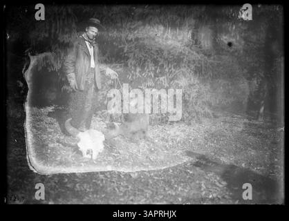 Questa fotografia della collezione Lee Moorhouse mostra un uomo con un orso incatenato addomesticato, parte delle fotografie storiche della University of Oregon Libraries. Foto Stock