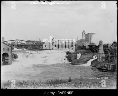 Fotografia delle Upper Falls sul fiume Spokane, Washington, con Echo Roller Mills sullo sfondo. Scattata da Lee Moorhouse, questa immagine fa parte della collezione University of Oregon Libraries. Foto Stock