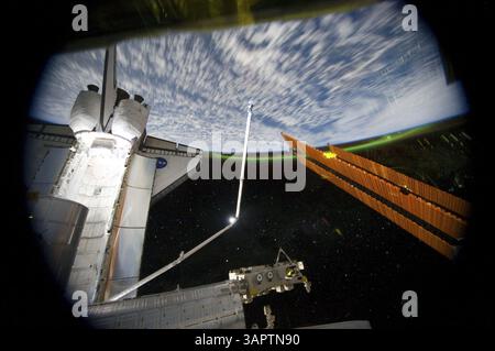 14 luglio 2011 - SSI, Lower Earth Orbit - Vista panoramica dalla stazione spaziale Internazionale verso la Terra, guardando oltre la baia di carico attraccata dallo Space Shuttle Atlantis e parte della stazione, incluso un pannello solare. La foto è stata scattata mentre il complesso congiunto passava sopra l'emisfero meridionale. L'aurora Australis o le luci del Sud possono essere viste all'orizzonte della Terra e sono visibili anche un certo numero di stelle. Atlantis tornerà con un modulo pompa ammoniaca guasto per aiutare la NASA a comprendere meglio il meccanismo di guasto e migliorare i progetti delle pompe per i sistemi futuri. STS-135 sarà il 33° volo di Atlant Foto Stock
