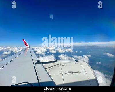 Vista dalla finestra sinistra di un airbus A320 neo da Austrian Airways, cielo blu e nuvole bianche Foto Stock