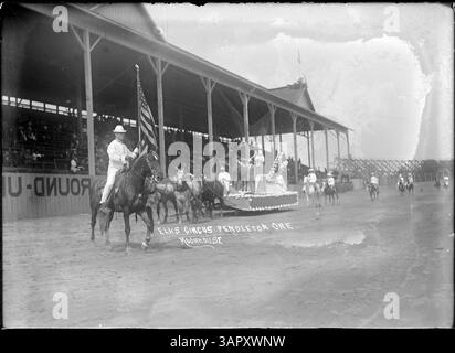 Questa fotografia di Lee Moorhouse mostra un galleggiante di alce al circo Elks di Pendleton, Oregon. L'immagine cattura un momento da una celebrazione locale, che riflette la cultura della comunità e degli eventi del tempo. Foto Stock