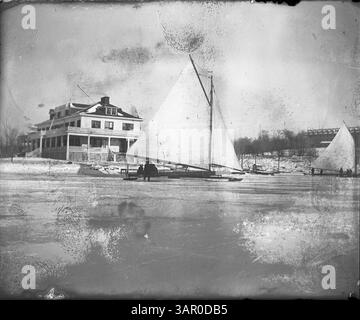 L'immagine mostra l'Ice Yacht Clubhouse sulla sinistra, con una barca completamente attrezzata al centro e un'altra all'estrema destra. Un edificio alberghiero e' parzialmente visibile all'estrema destra della cornice. La scena cattura una fredda giornata invernale a Deephaven Bay con i motoscafi che si preparano per la stagione. Foto Stock