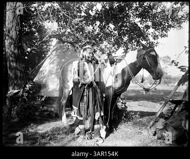 Fotografia di Lee Moorhouse che mostra un uomo nativo americano con un pony. La foto è un ritratto che riflette la vita dei nativi americani del XX secolo. Foto Stock