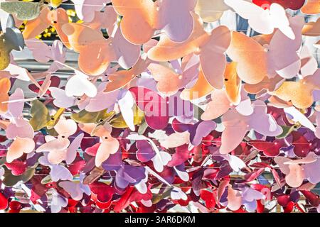 ghirlande decorative multicolore con farfalle su una lenza da pesca che ondeggia al vento all'esterno: Foto Stock