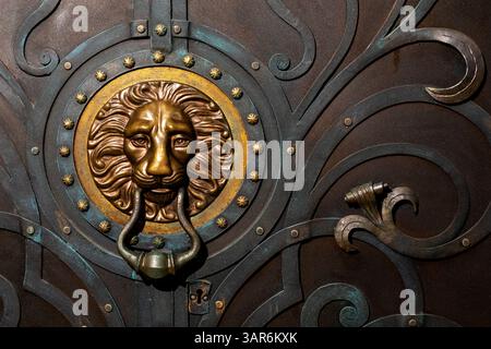 maniglia metallica della porta sotto forma di testa di leone Foto Stock