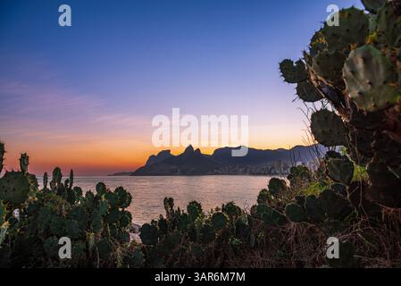 Tramonto incorniciato sulla spiaggia di Ipanema da Pedra do Arpoador - Rio de Janeiro, Brasile Foto Stock