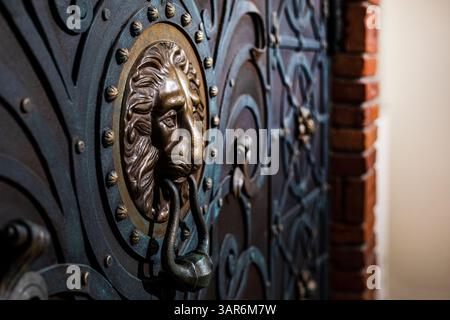 maniglia metallica della porta sotto forma di testa di leone nel profilo Foto Stock