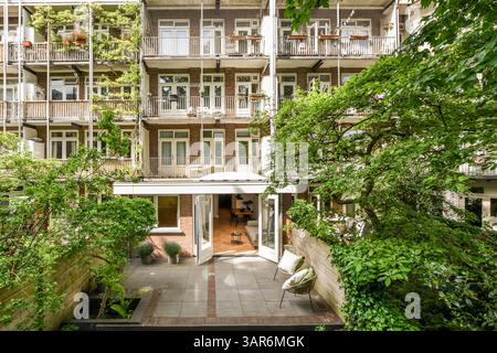 un edificio di appartamenti con molte piante e alberi in primo piano - l'immagine è presa dall'alto, guardando verso il basso Foto Stock