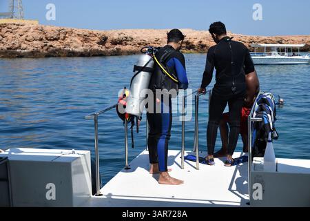 Daymaniyat Islands, Oman - 2 aprile 2025: Immersioni subacquee. Due subacquei si preparano ad immergersi da una barca. Golfo dell'Oman, isole ad Daymaniyat. Sultanato di Om Foto Stock