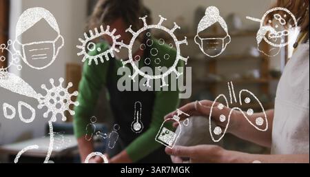 Immagine di cellule covid 19 e icone sopra le persone che indossano maschere facciali in un laboratorio di ceramica Foto Stock