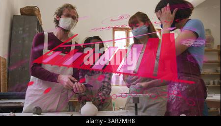 Amici diversi che realizzano pezzi di ceramica in studio di ceramica con utensili e argilla non smaltata Foto Stock