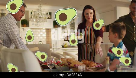 Immagine di icone di avocado sulla felice famiglia caucasica che cena Foto Stock
