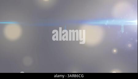 Immagine di un fascio luminoso che si muove su spot di luce bianchi bokeh su sfondo grigio Foto Stock