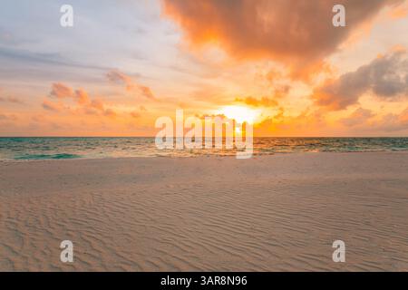 Spiaggia tropicale vuota al tramonto. Orizzonte d'oro, onde marine calme, sabbia soffice, primo piano del cielo colorato. Sognate il paesaggio estivo una natura mozzafiato e stimolante Foto Stock