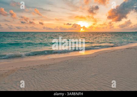 Spiaggia tropicale vuota al tramonto. Orizzonte d'oro, onde marine calme, sabbia soffice, primo piano del cielo colorato. Sognate il paesaggio estivo una natura mozzafiato e stimolante Foto Stock