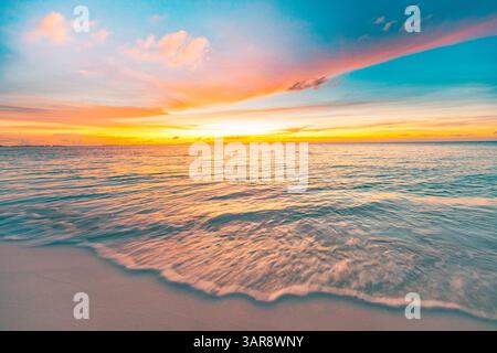 Colorato, tranquillo tramonto, spiaggia tropicale dell'isola, onde morbide, sabbia calda, luce dorata, splendida vacanza estiva a riva. Paesaggio naturale incredibile Foto Stock