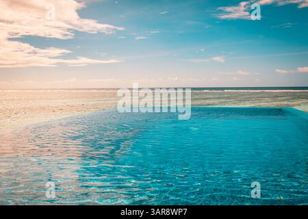 Piscina a sfioro astratta al tramonto con riflessi di luce estiva, perfetta per un design moderno e un'atmosfera di lusso che ispira la vista tropicale Foto Stock