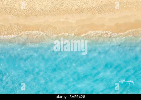 Vista dall'alto, tranquilla spiaggia tropicale, mare turchese, sabbia dorata, onde tranquille, luce solare estiva, stupenda per i viaggi in vacanza. Spiaggia della baia oceanica Foto Stock