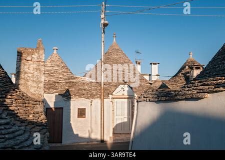 Trulli su una strada deserta ad Alberobello, in Puglia, in Italia Foto Stock