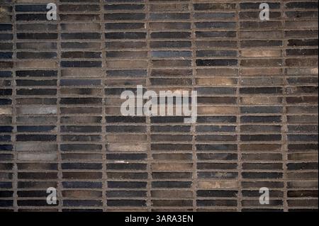 Parete in mattoni marrone scuro che crea una splendida texture di sfondo, perfetta per progetti di design Foto Stock