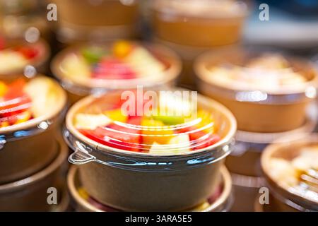 Macedonie di frutta preconfezionate esposte in un frigorifero commerciale Foto Stock