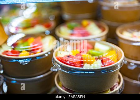 Macedonie di frutta preconfezionate esposte in un frigorifero commerciale Foto Stock