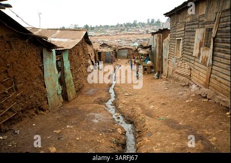 1 settembre 2009 - Nairobi, Kenya - Un flusso di acqua inquinata scorre lungo una strada sterrata nell'insediamento informale Kibera a Nairobi, Kenya. Più di un milione di persone affollano la baraccopoli, che si trova su meno di un miglio quadrato di terreno a circa 5 miglia dal centro di Nairobi in Kenya. (Immagine di credito: © David Snyder/ZUMA Press) Foto Stock