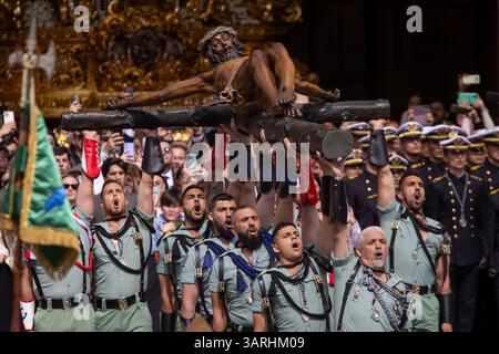 Un gruppo di legionari trasporta il Cristo di Mena durante il trasferimento del Cristo di Mena il giovedì Santo, una delle processioni della settimana Santa più famose di tutta la Spagna, sia per ciò che rappresenta sia per la partecipazione della Legione che canta "El Novio de la Muerte", un canto emblematico diventato l'inno non ufficiale della Legione spagnola. Foto Stock