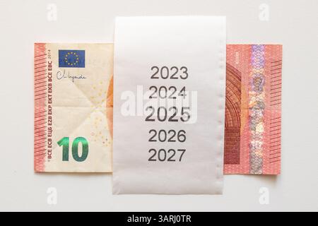 Banconota da dieci euro e assegno con anni dal 2023 al 2027 su sfondo bianco, pianificando il denaro per il futuro Foto Stock