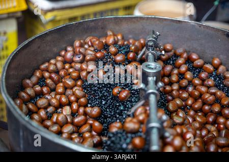 Arrostire le castagne con il carbone Foto Stock