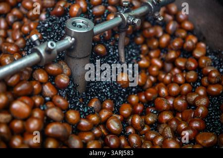 Arrostire le castagne con il carbone Foto Stock