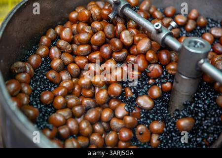 Arrostire le castagne con il carbone Foto Stock
