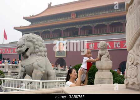 01 lug 2013 - Pechino, Cina - Una madre stava sollevando il figlio per permettergli di toccare la scultura del leone, Pechino, Cina. (Immagine di credito: © Jiwei Han/ZUMAPRESS.com) Foto Stock
