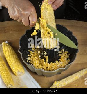 27 giugno 2013 - Chicago, il, Stati Uniti - rimuovere i chicchi da una pannocchia di mais utilizzando una padella. (Immagine di credito: © Bill Hogan/MCT/ZUMAPRESS.com) Foto Stock