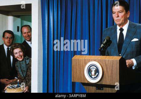 18 dicembre 2003; Washington, DC, USA; FOTO DEL FILE (data sconosciuta): il 40° presidente degli Stati Uniti (1981-89) RONALD REAGAN tiene un discorso mentre sua moglie, NANCY REAGAN, e diversi membri del personale si nascondono dietro la tenda preparandosi a sorprenderlo con una torta di compleanno. . Reagan come presidente. Nato il 6 febbraio 1911 a Tampico, Illinois. (Immagine di credito: Michael Evans/ZUMAPRESS.com) Foto Stock