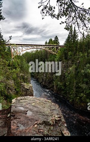 Questo ponte ferroviario mozzafiato attraversa il fiume Ämån, annidato nei lussureggianti e verdi paesaggi del Deep Canyon Storstupet a Orsa in Svezia. Foto Stock