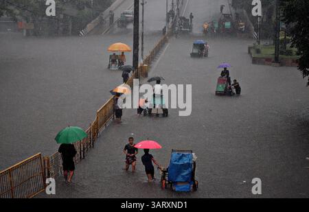 20 agosto 2013 - Manila, Filippine - i risciò attraversano una strada allagata a Manila, Filippine, 20 agosto 2013. Forti piogge intensificate dalla tempesta tropicale Trami continuò per un secondo giorno, causando l'aumento del livello dell'acqua e spingendo migliaia di persone che vivono in zone basse a fuggire dalle loro case. (Immagine di credito: © Ezra Acayan/ZUMAPRESS.com) Foto Stock