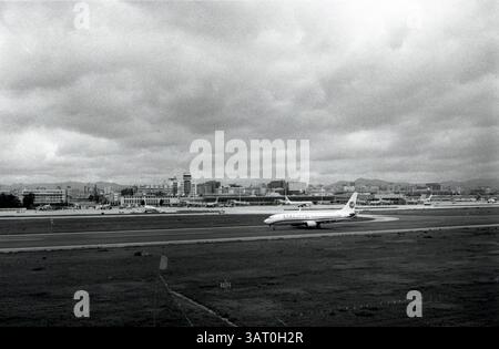 Pista aeroportuale trafficata con un aereo Boeing in preparazione al decollo in mezzo a cieli sovrastati: Xiamen Airlines Boeing 737 in rullaggio all'ultimo giorno dell'aeroporto di Kunming Wujiaba, 2012, Kunming, Yunnan, Cina Foto Stock