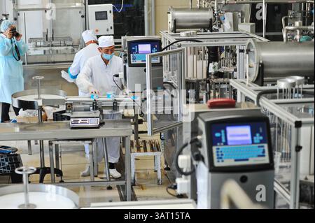 Imbottigliamento e cernita di prodotti finiti a base di latte fermentato in fabbrica. Foto Stock