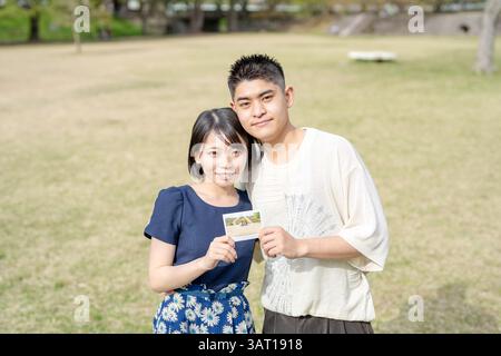 Nella scena primaverile di maggio, c'è un parco senza equipaggio, la prefettura di Aichi. Le coppie giapponesi nei primi anni '20 trascorrono del tempo insieme. Hanno un piccolo pict Foto Stock