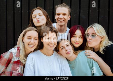 Adolescenti che fanno facce divertenti in posa per una foto di gruppo Foto Stock