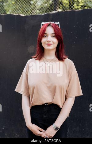 Giovane donna con i capelli rossi sorride all'aperto Foto Stock
