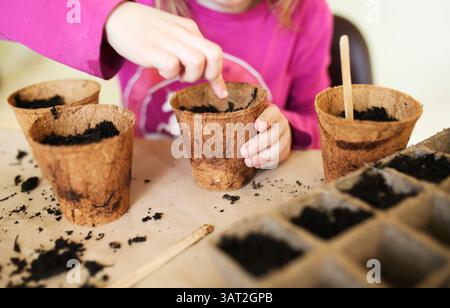 Bambini che piantano semi in pentole di avviamento Foto Stock