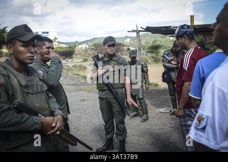 21 luglio 2013 - Caracas, Miranda, Venezuela - i locali sono bloccati dall'ingresso in un appezzamento contestato di terra dopo che i membri della Guardia Nazionale venezuelana sono arrivati per rimuovere circa 200 persone che avevano occupato la terra, sperando di costruirvi case. Il governo socialista dice che la proprietà di 10 ettari sarà il sito di una serie di edifici residenziali pubblici, un progetto che è stato avviato quattro anni fa ma deve ancora iniziare. Secondo un residente, "vogliamo solo che il governo inizi a costruire, o che ci dia la terra e lo faremo noi stessi. (Immagine di credito: © Charles Mostol Foto Stock