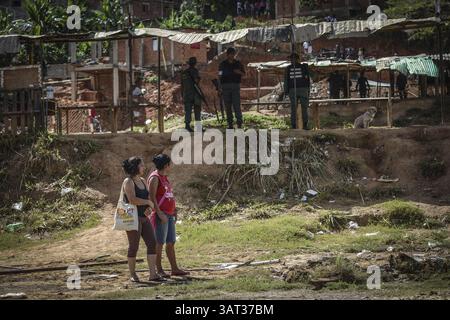 21 luglio 2013 - Caracas, Miranda, Venezuela - la gente del posto guarda fuori una proprietà contesa dopo che i membri della Guardia Nazionale venezuelana sono arrivati per rimuovere circa 200 persone che avevano occupato la terra, sperando di costruirvi case. Il governo socialista dice che la proprietà di 10 ettari sarà il sito di una serie di edifici residenziali pubblici, un progetto che è stato avviato quattro anni fa ma deve ancora iniziare. Secondo un residente, "vogliamo solo che il governo inizi a costruire, o che ci dia la terra e lo faremo noi stessi. (Immagine di credito: © Charles Mostoller/ZUMAPRESS.com) Foto Stock