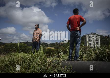 21 luglio 2013 - Caracas, Miranda, Venezuela - la gente del posto guarda fuori una proprietà contesa dopo che i membri della Guardia Nazionale venezuelana sono arrivati per rimuovere circa 200 persone che avevano occupato la terra, sperando di costruirvi case. Il governo socialista dice che la proprietà di 10 ettari sarà il sito di una serie di edifici residenziali pubblici, un progetto che è stato avviato quattro anni fa ma deve ancora iniziare. Secondo un residente, "vogliamo solo che il governo inizi a costruire, o che ci dia la terra e lo faremo noi stessi. (Immagine di credito: © Charles Mostoller/ZUMAPRESS.com) Foto Stock
